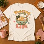 Noodling Through Life cute food graphic t-shirt cozy flat lay in natural.