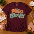 Miso Sleepy cute food graphic t-shirt cozy flat lay in maroon.