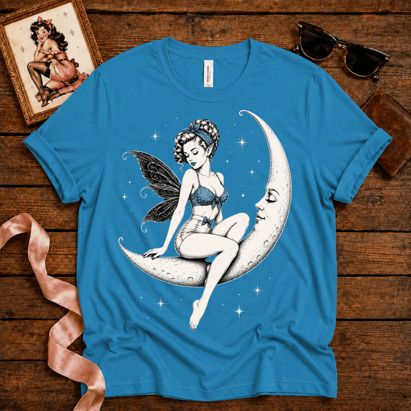 Moonlit Fairy pinup graphic t-shirt cozy flat lay in aqua.