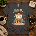 Sip. Sigh. Repeat. coffee graphic t-shirt cozy flat lay in asphalt.