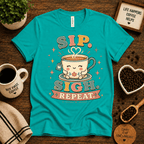 Sip. Sigh. Repeat. coffee graphic t-shirt cozy flat lay in heather sea green.