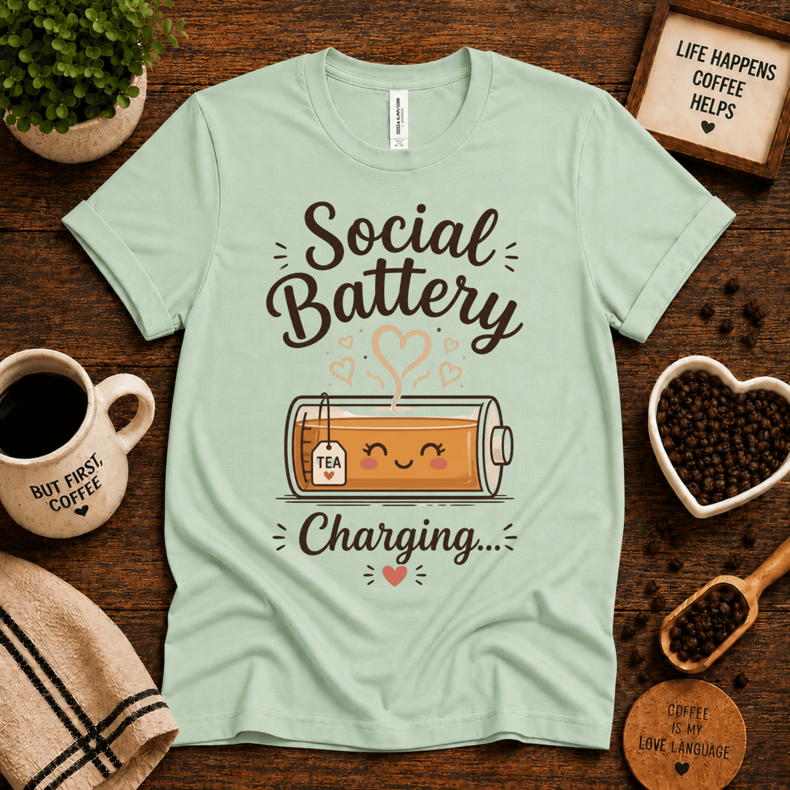Social Battery of Tea graphic t-shirt cozy flat lay in mint.