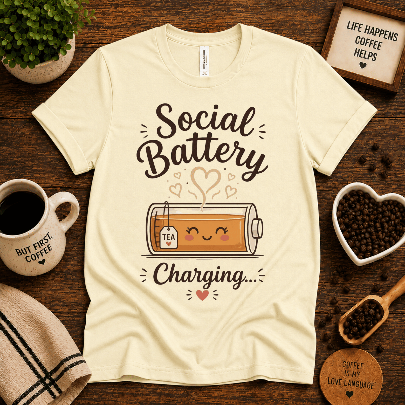 Social Battery of Tea graphic t-shirt cozy flat lay in natural.