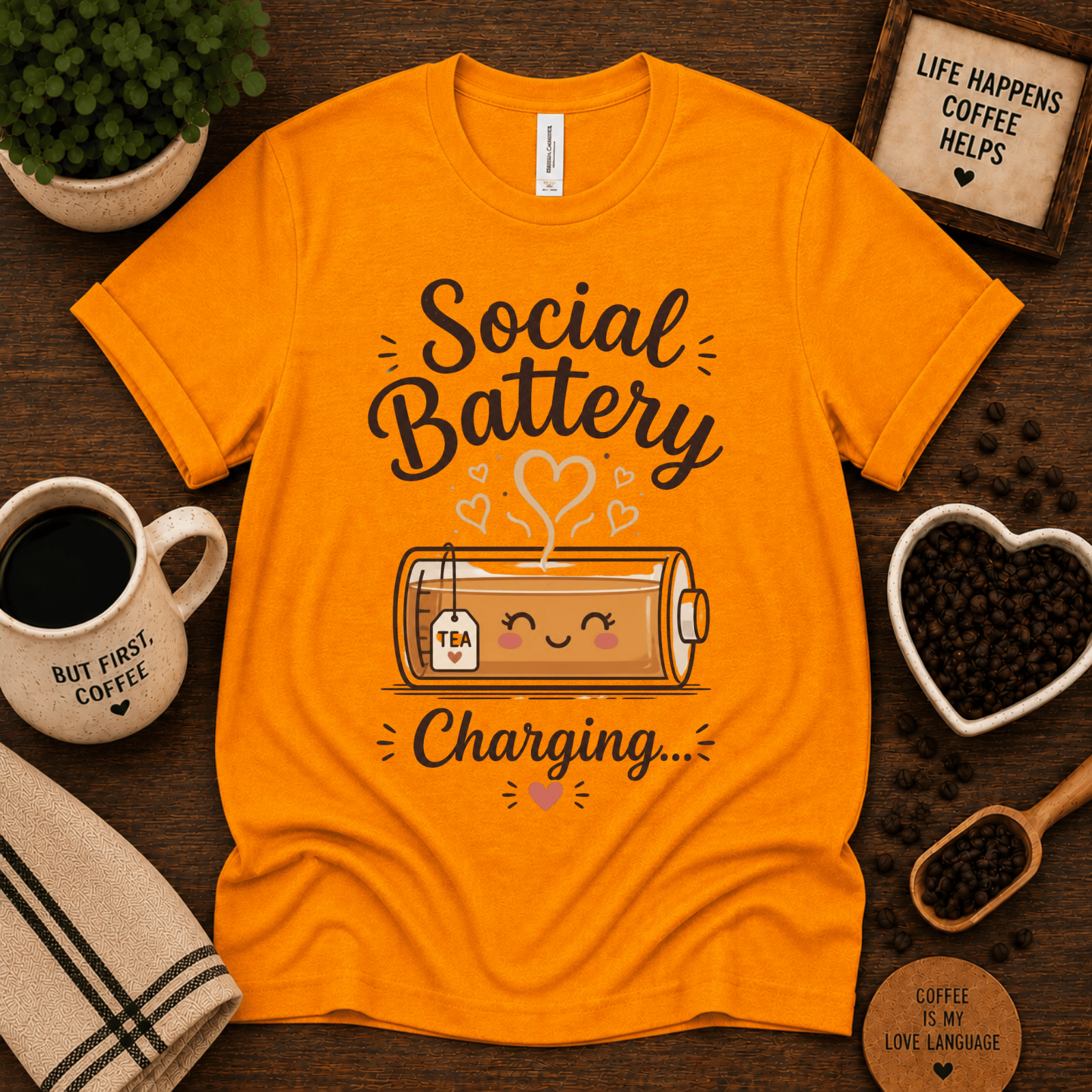 Social Battery of Tea graphic t-shirt cozy flat lay in gold.
