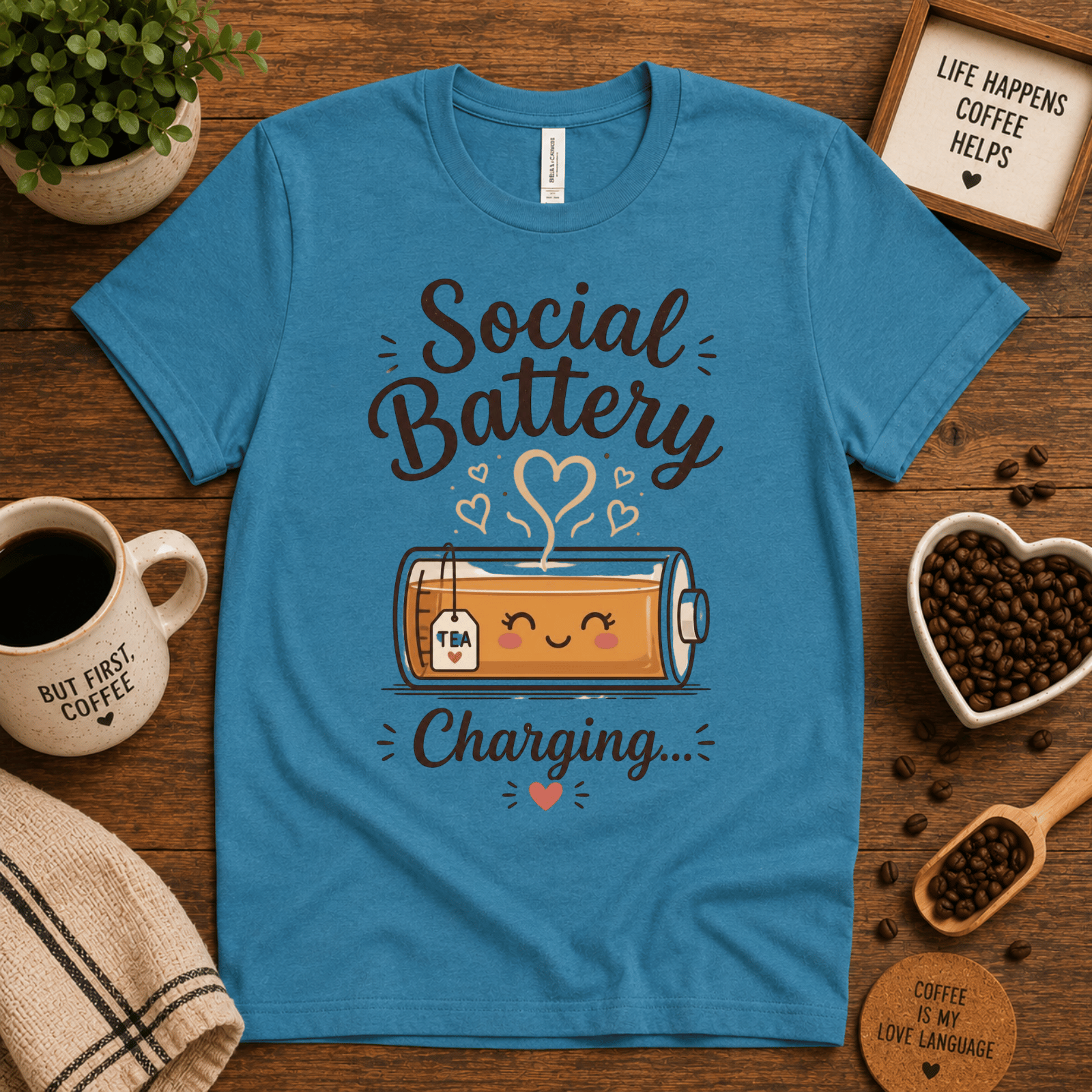 Social Battery of Tea graphic t-shirt cozy flat lay in aqua.