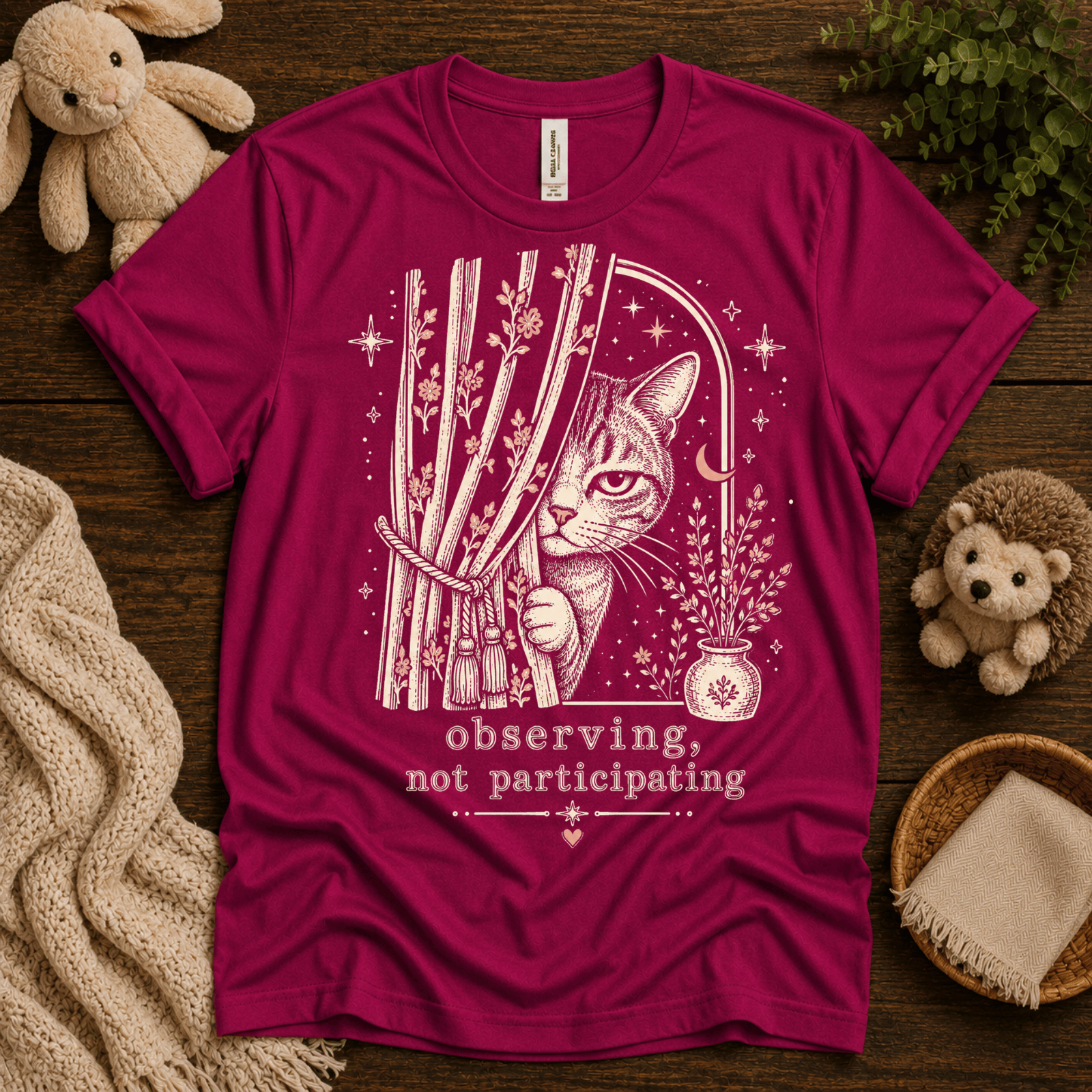 Cat Observing cute animal graphic t-shirt cozy flat lay in berry.