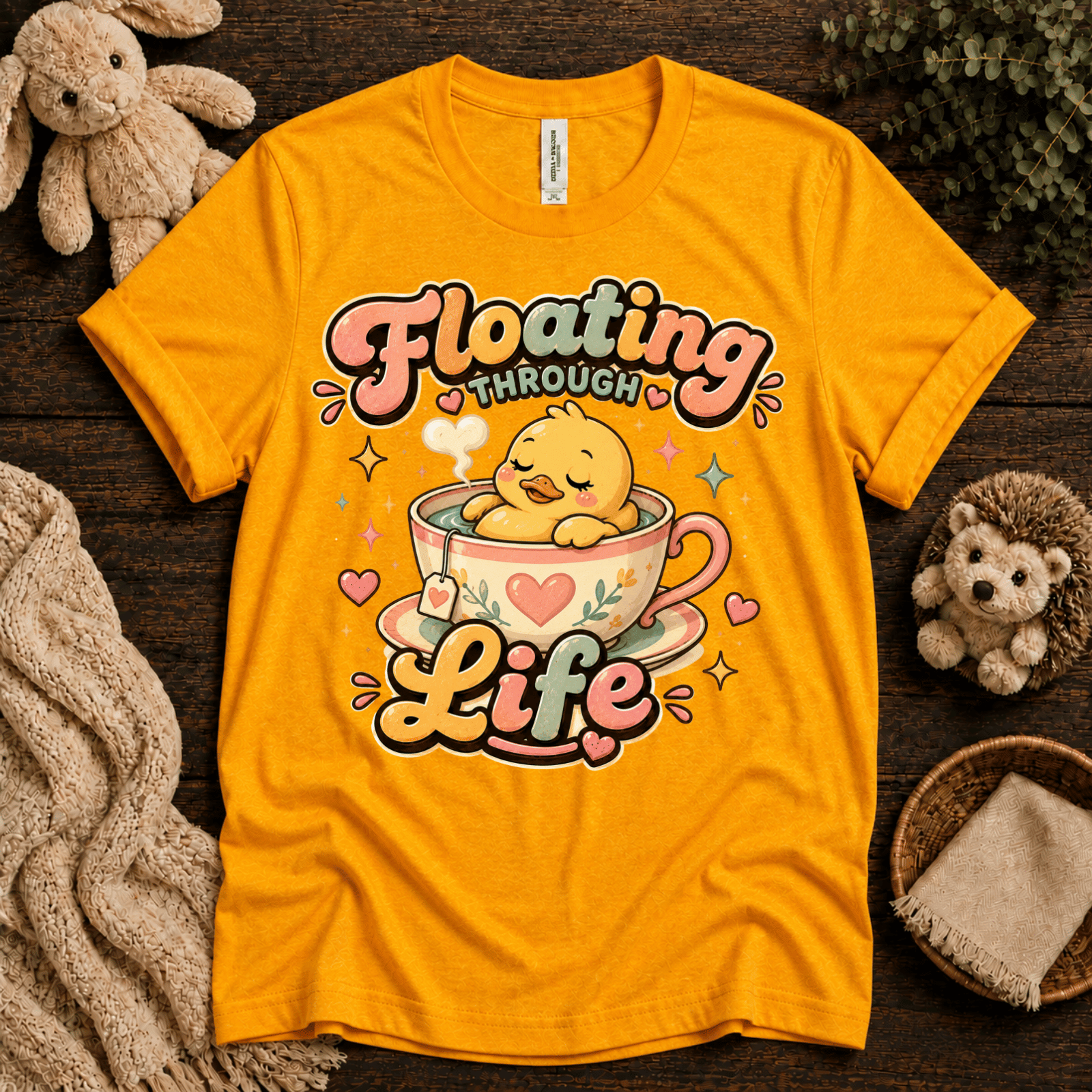 Floating Through Life cute animal graphic t-shirt cozy flat lay in gold.