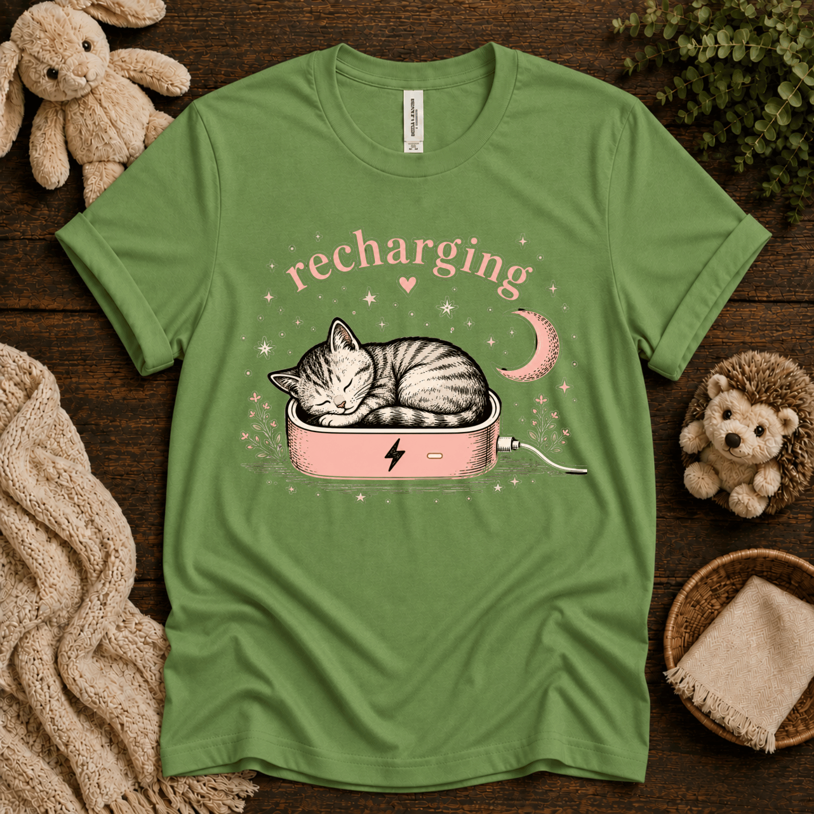 Recharging Cat cute animal graphic t-shirt cozy flat lay in leaf.