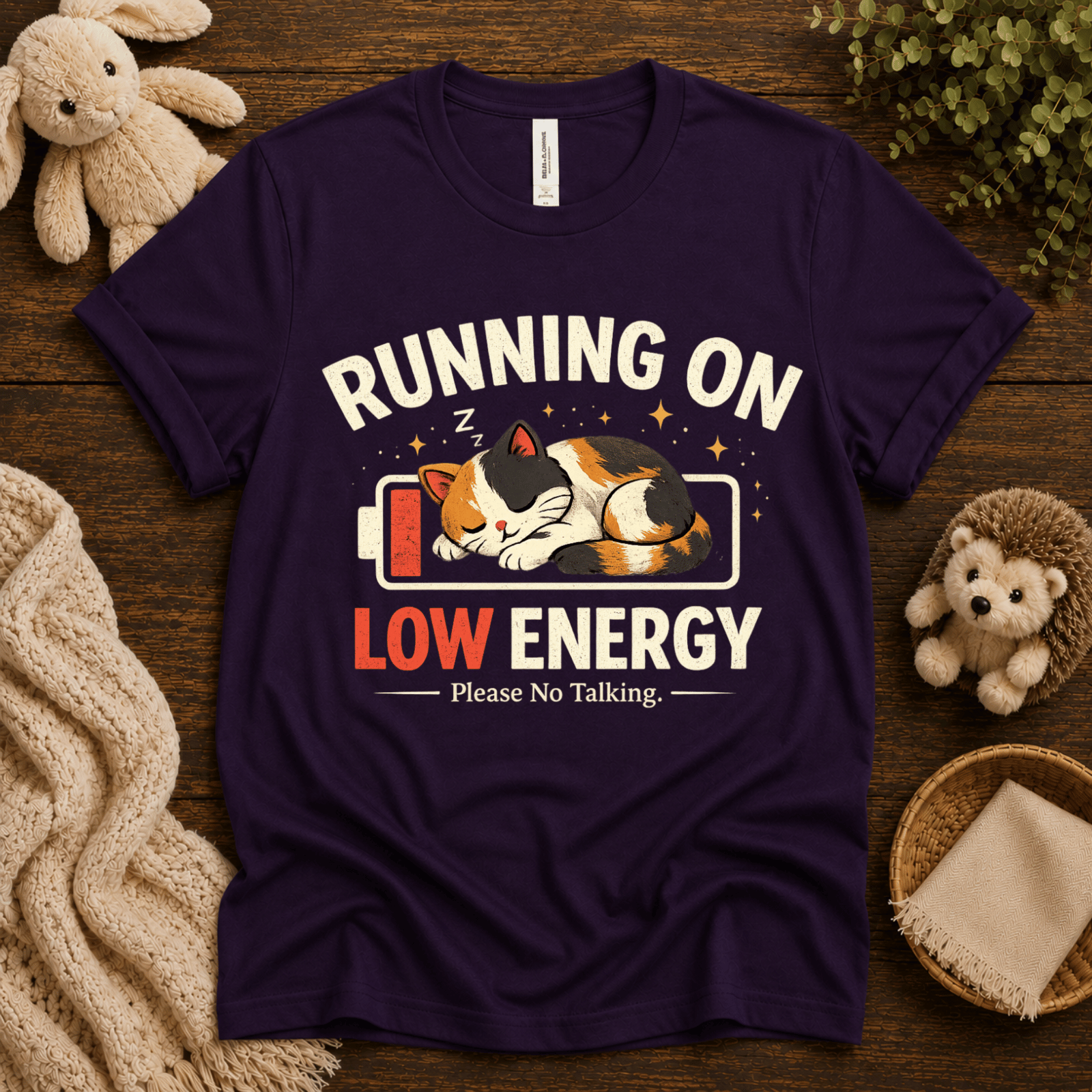 Low Energy Cat cute animal graphic t-shirt cozy flat lay in team purple.