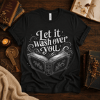 Let It Wash Over You whimsical book graphic t-shirt cozy flat lay in vintage black.