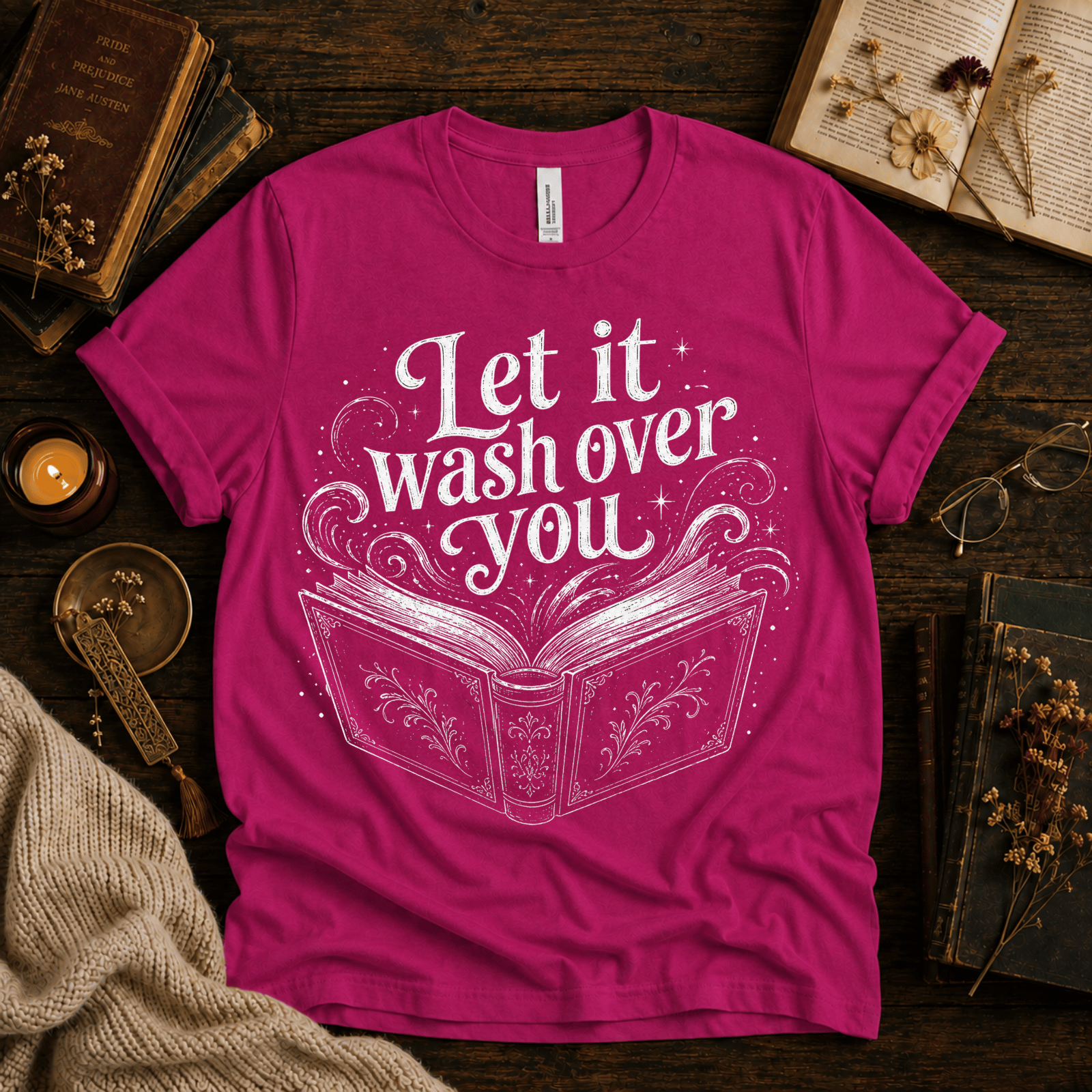 Let It Wash Over You whimsical book graphic t-shirt cozy flat lay in charity pink.