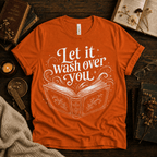 Let It Wash Over You whimsical book graphic t-shirt cozy flat lay in burnt orange.