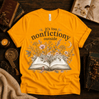 Nonfictiony whimsical book graphic t-shirt cozy flat lay in gold.
