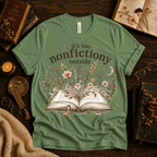 Nonfictiony whimsical book graphic t-shirt cozy flat lay in leaf.