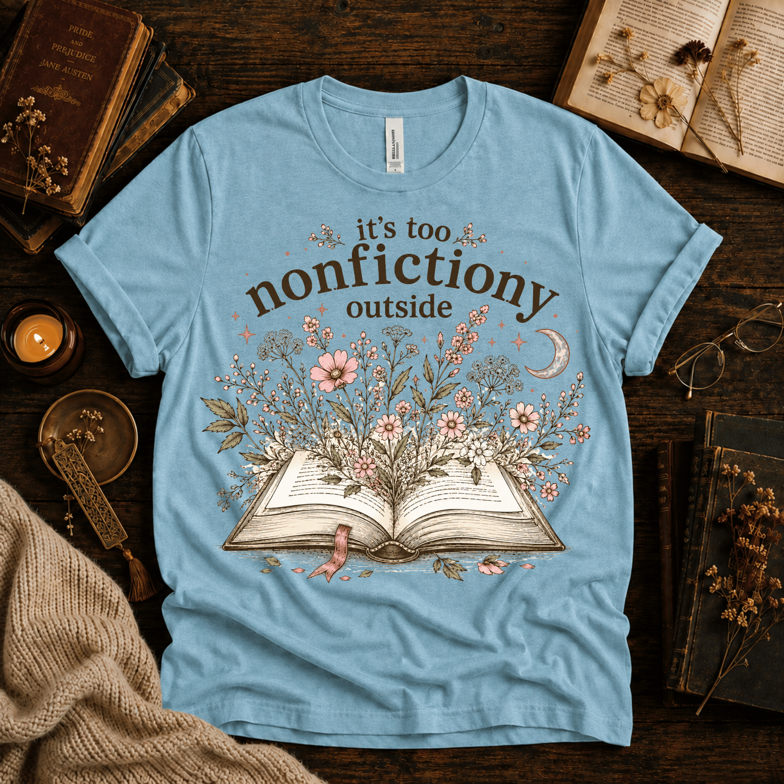Nonfictiony whimsical book graphic t-shirt cozy flat lay in baby blue.