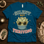 Silent But Thriving funny plant graphic t-shirt cozy flat lay in deep teal.