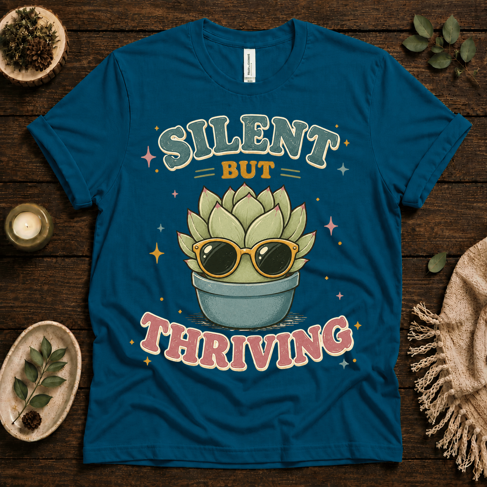Silent But Thriving funny plant graphic t-shirt cozy flat lay in deep teal.