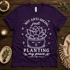 Planting My Peace cute plant graphic t-shirt cozy flat lay in team purple.