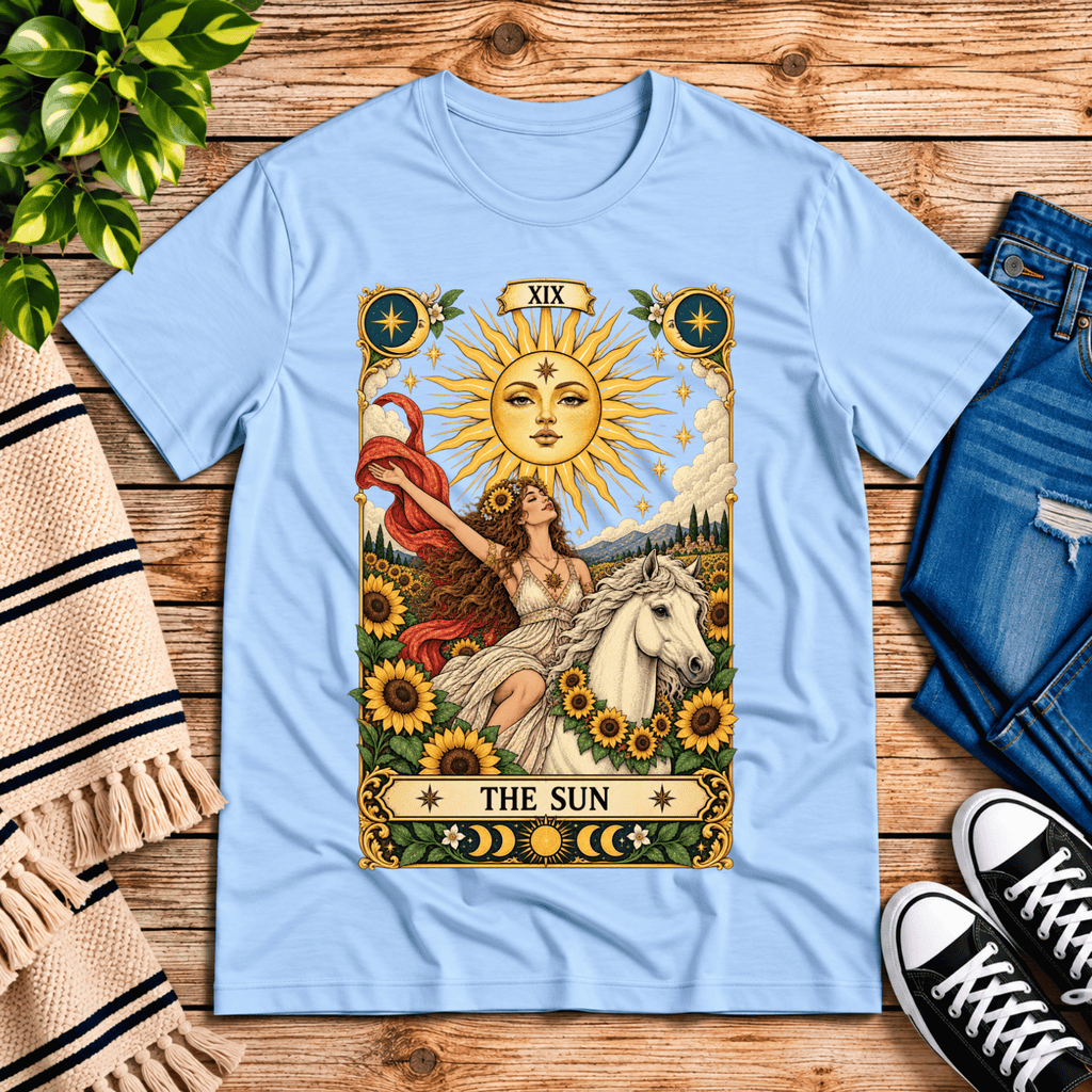 The Sun tarot card mystical graphic t-shirt cozy flat lay in baby blue.