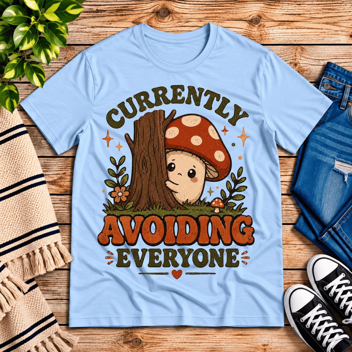 Currently Avoiding funny cottagecore graphic t-shirt cozy flat lay in baby blue.