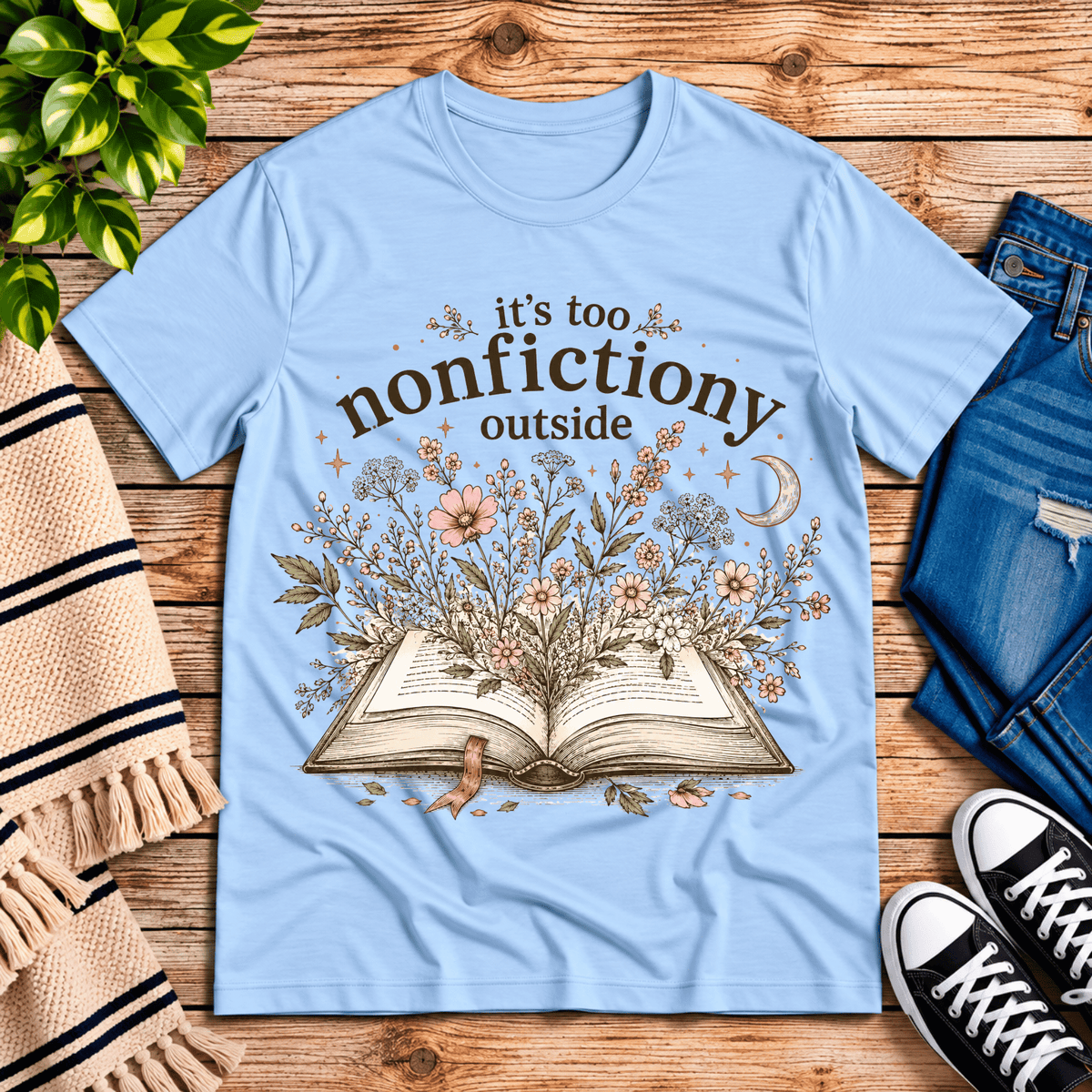 Nonfictiony whimsical book graphic t-shirt cozy flat lay in baby blue.