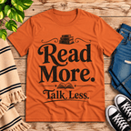Talk Less funny book graphic t-shirt cozy flat lay in burnt orange.