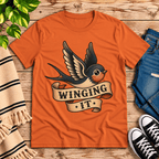 Winging It cute animal graphic t-shirt cozy flat lay in burnt orange.