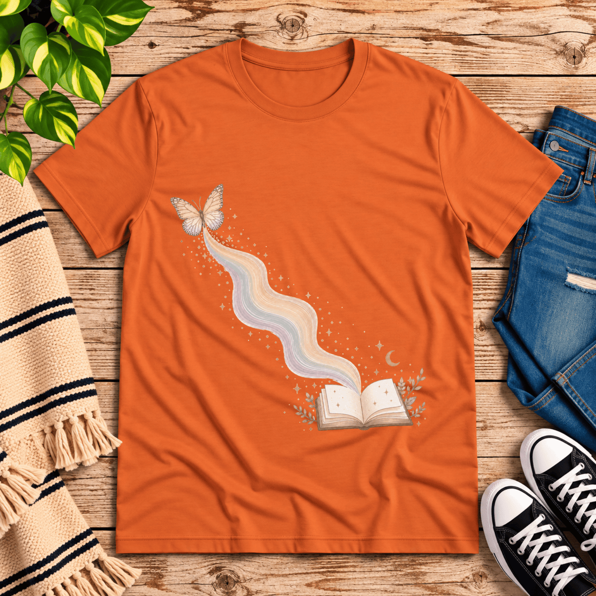 Rainbow Book whimsical book graphic t-shirt cozy flat lay in burnt orange.
