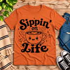 Sippin' on Life cute coffee graphic t-shirt cozy flat lay in burnt orange.