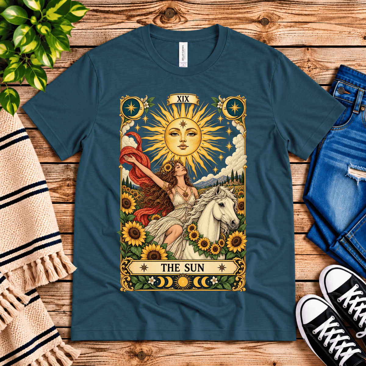 The Sun tarot card mystical graphic t-shirt cozy flat lay in deep teal.