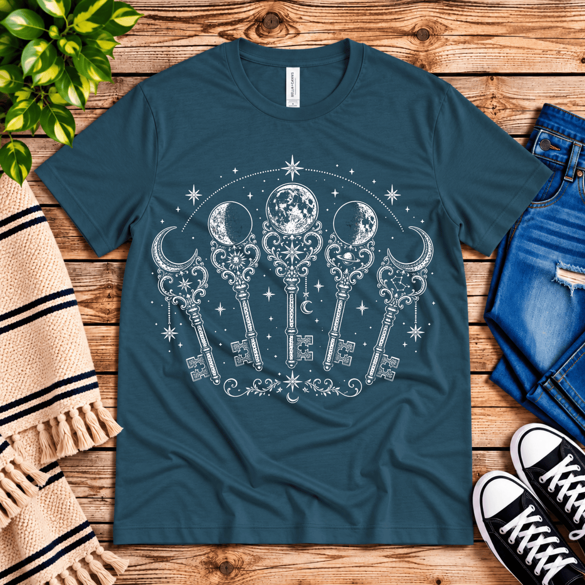 Moon Phase Keys celestial graphic t-shirt cozy flat lay in deep teal.
