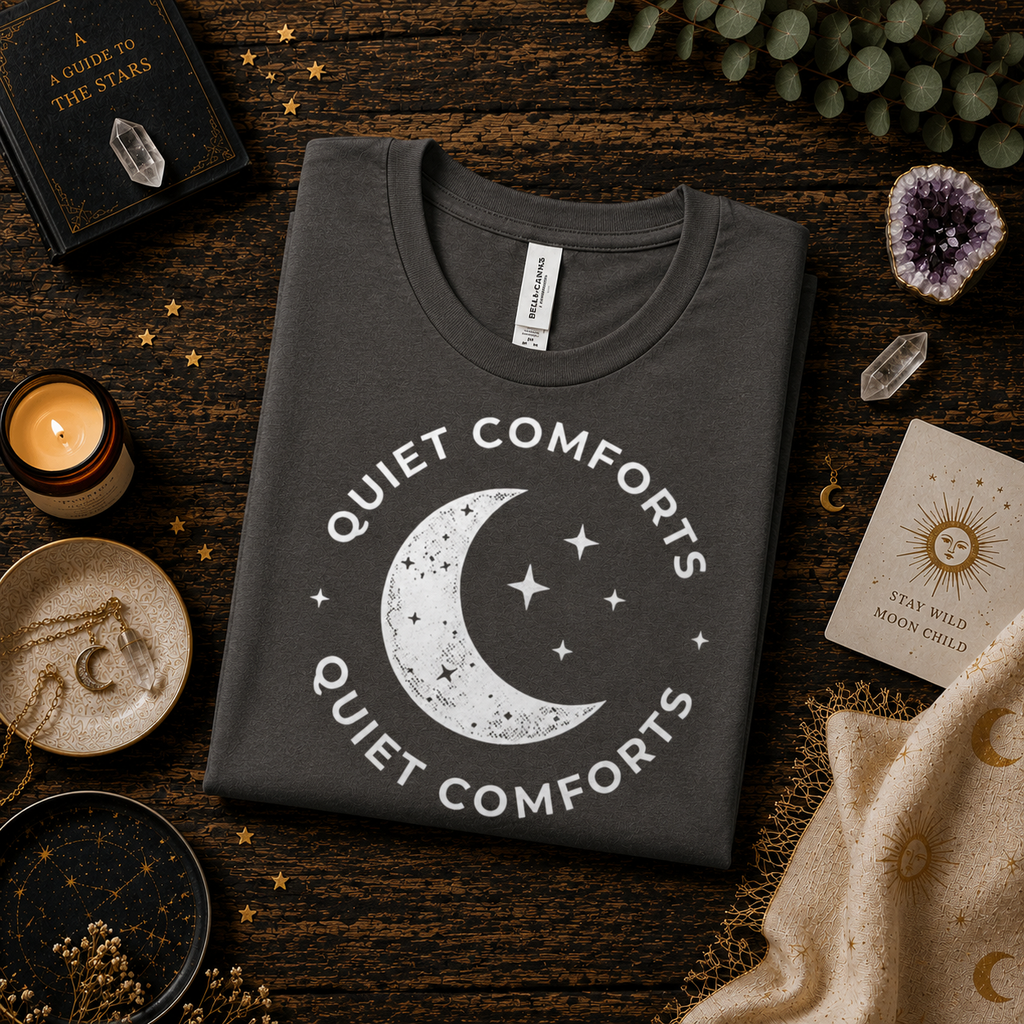A folded mockup of Quiet Comforts white print graphic t-shirt in asphalt.