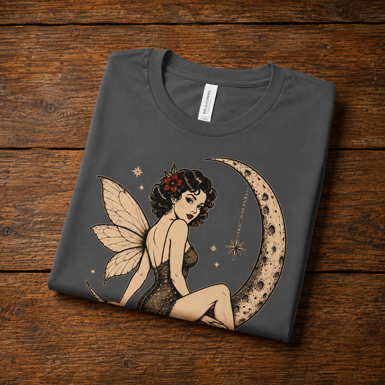 An asphalt Red Rose Moon pinup fairy graphic t-shirt in a folded mockup.