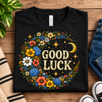 A folded mockup of Good Luck Gold cute celestial graphic t-shirt in vintage black.