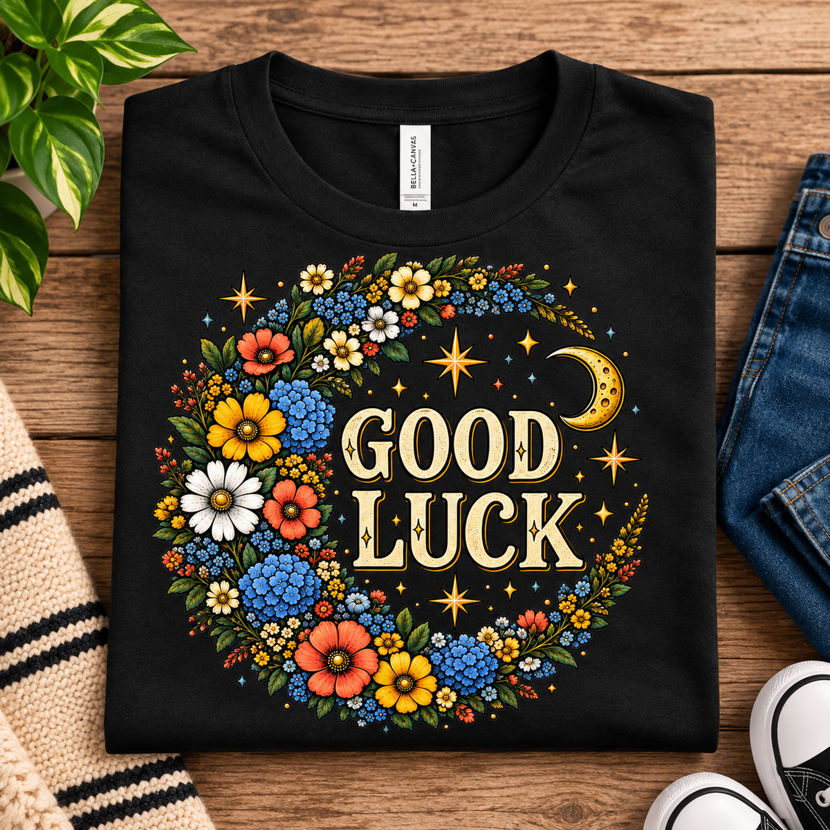 A folded mockup of Good Luck Gold cute celestial graphic t-shirt in vintage black.