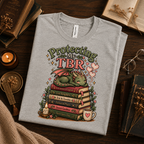 A folded mockup of Protecting My TBR cute book graphic t-shirt in athletic heather.