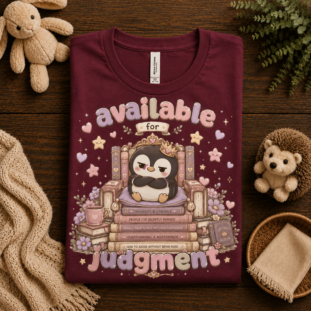 A folded mockup of Available For Judgement graphic t-shirt in maroon.