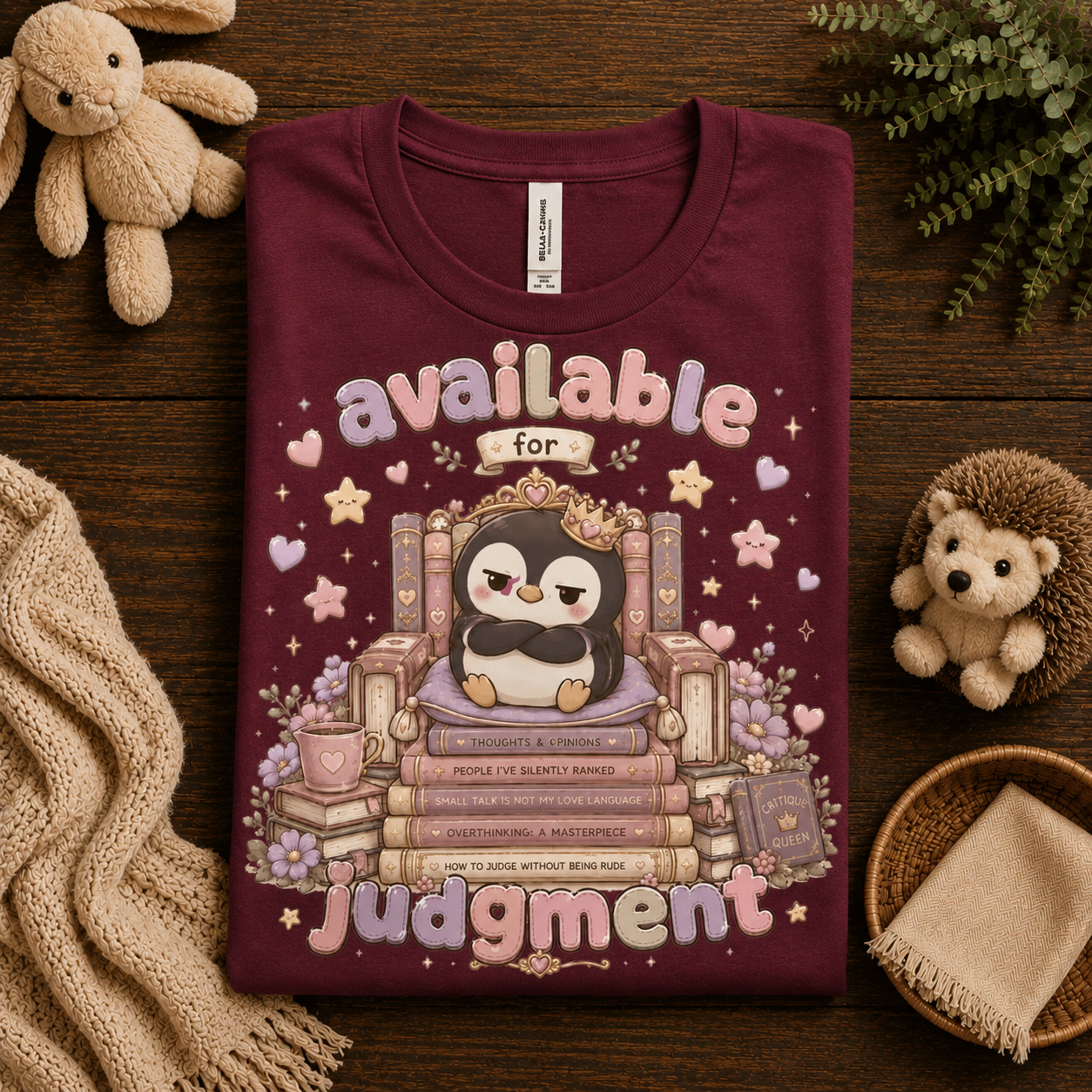 A folded mockup of Available For Judgement graphic t-shirt in maroon.