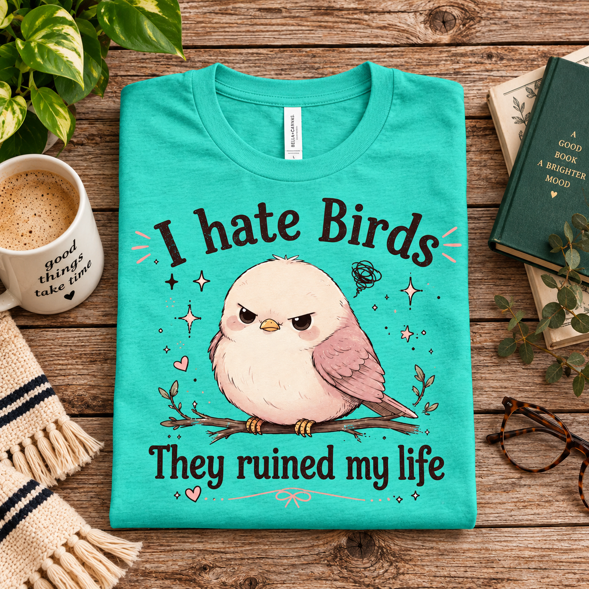 A folded mockup of I hate Birds cute animal graphic t-shirt in heather sea green.