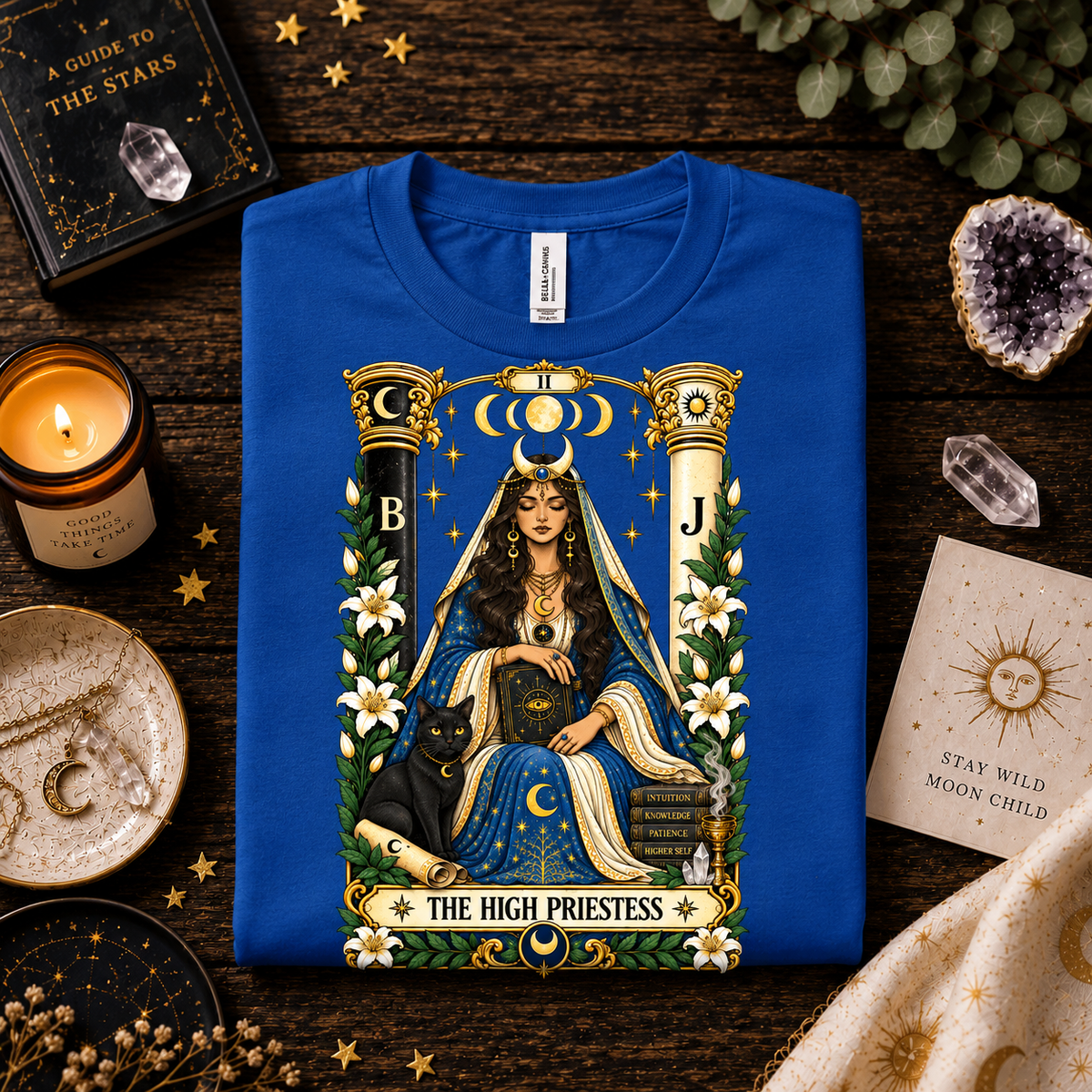 A folded mockup of The High Priestess tarot card graphic t-shirt in true royal.