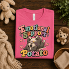 A folded mockup of Emotional Support Potato graphic t-shirt in charity pink.