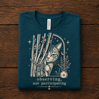 A folded mockup of Cat Observing graphic t-shirt in deep teal.