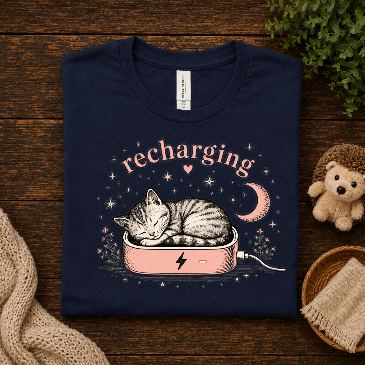 A folded mockup of Recharging Cat cute animal graphic t-shirt in navy.
