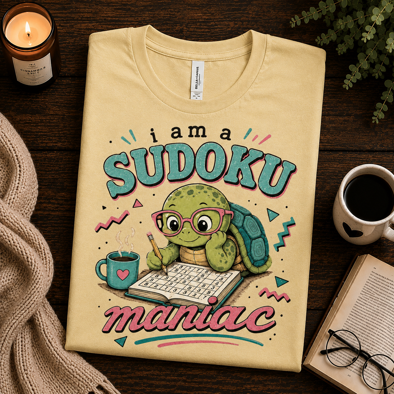 A folded mockup of Sudoku Maniac funny introvert graphic t-shirt in natural.