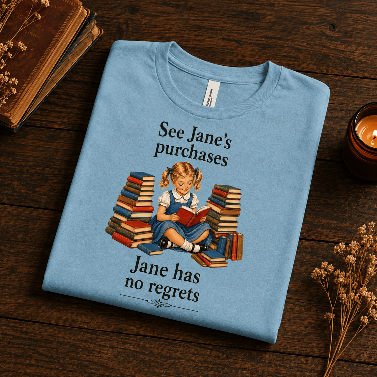 A folded mockup of See Jane's Purchases vintage book graphic t-shirt in baby blue.