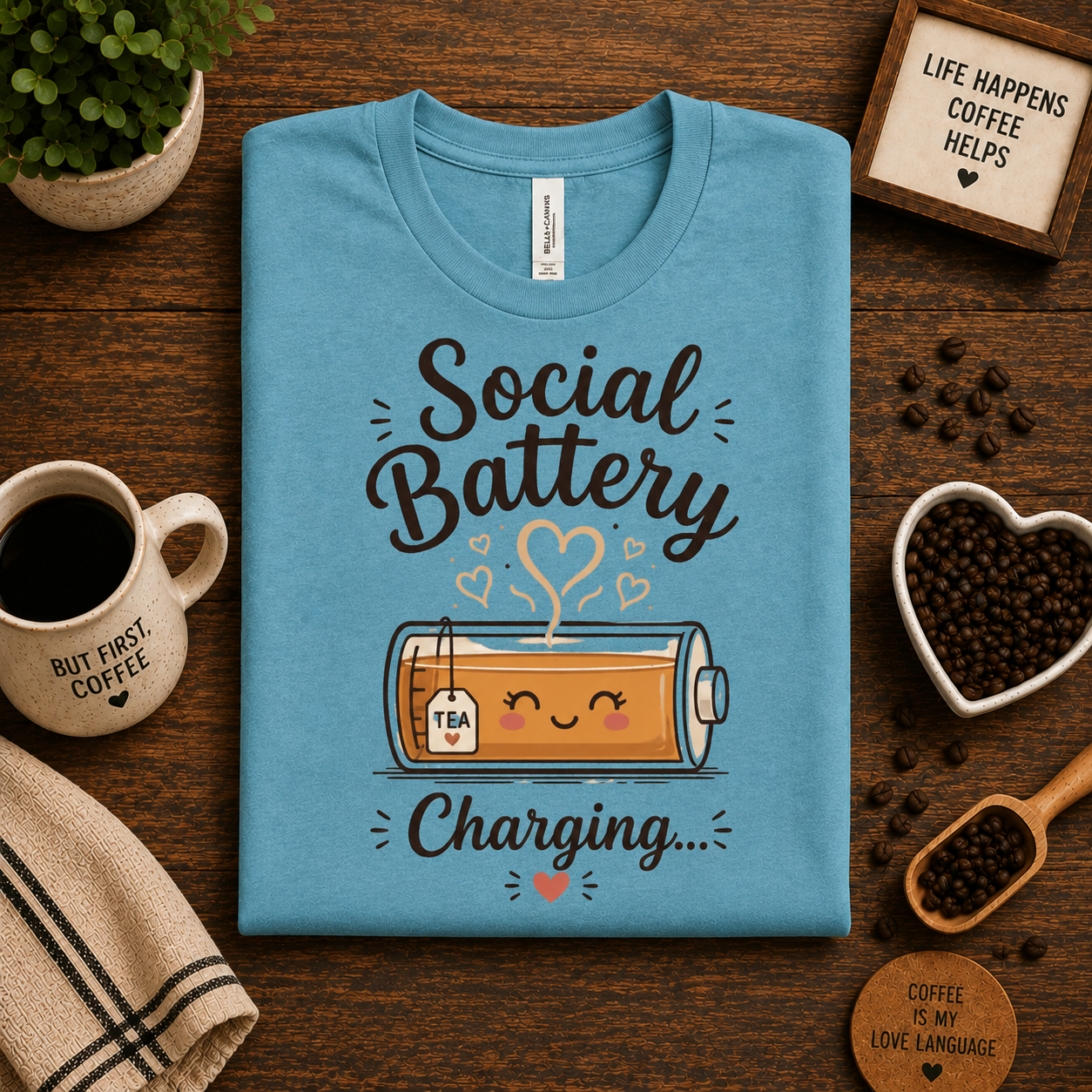 A folded mockup of Social Battery of Tea graphic t-shirt in aqua.