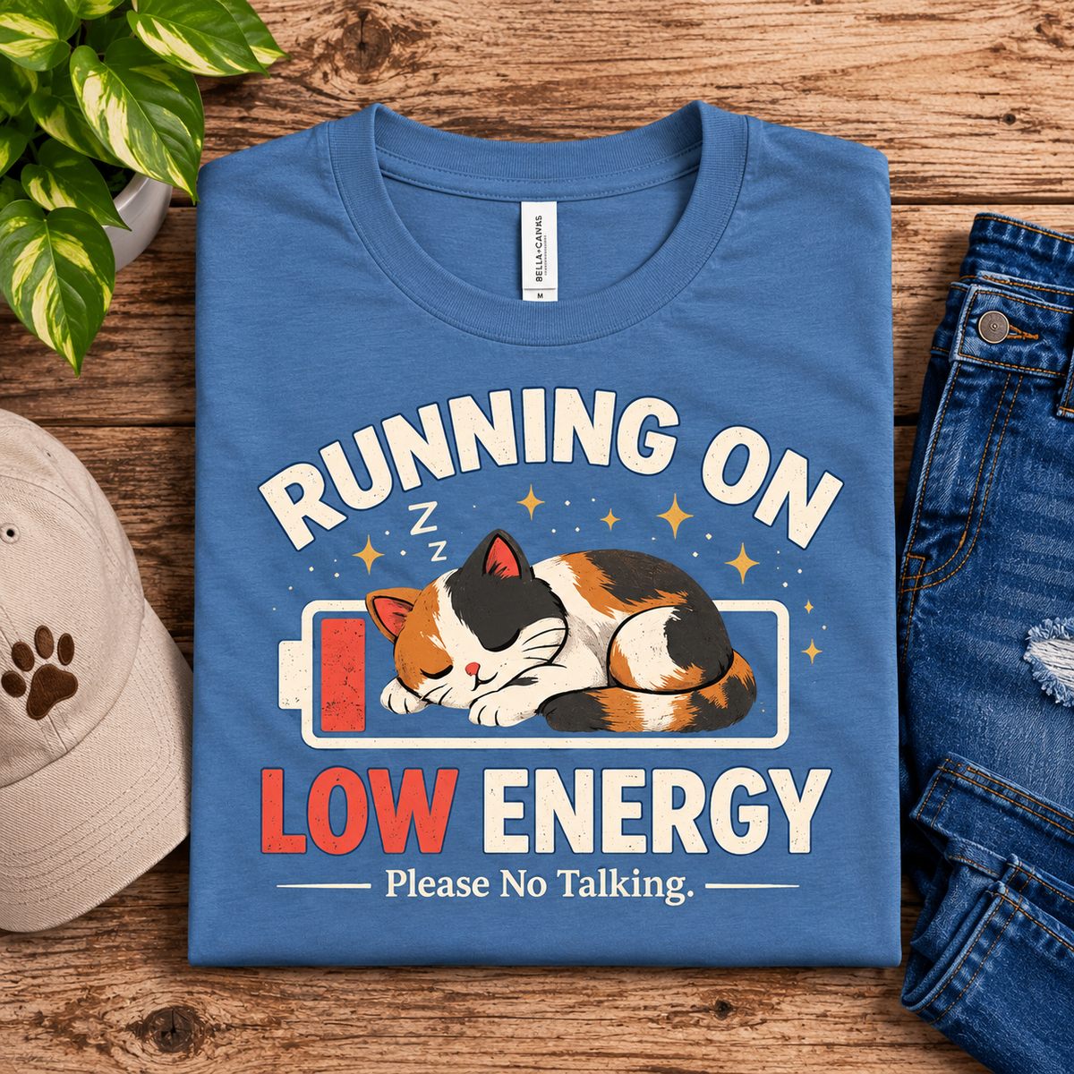 A folded mockup of Low Energy Cat cute animal graphic t-shirt in steel blue.
