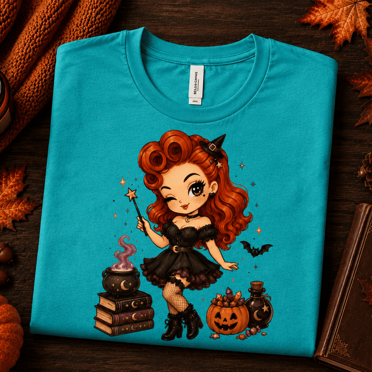 A folded mockup of Witchy Wendy halloween pinup graphic t-shirt in heather sea green.
