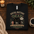 A folded mockup of Social Battery Dead funny introvert graphic t-shirt in vintage black.