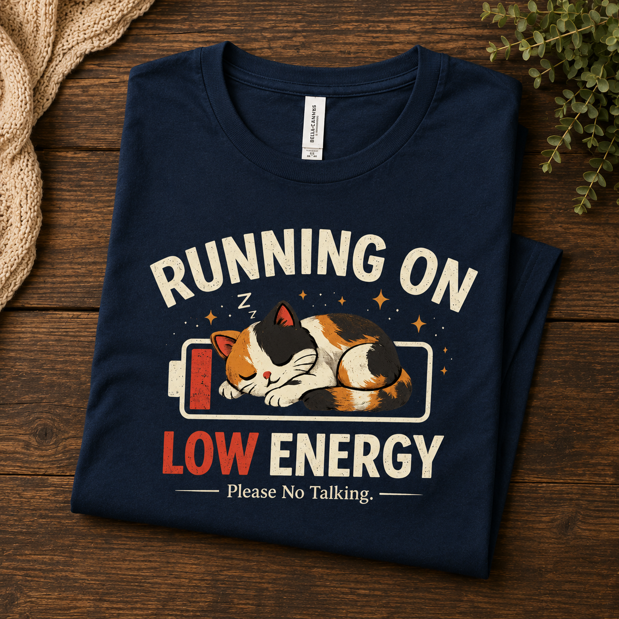 A folded mockup of Low Energy Cat cute animal graphic t-shirt in navy.